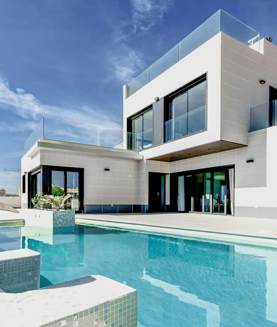 A modern home with large windows and a poolside terrace